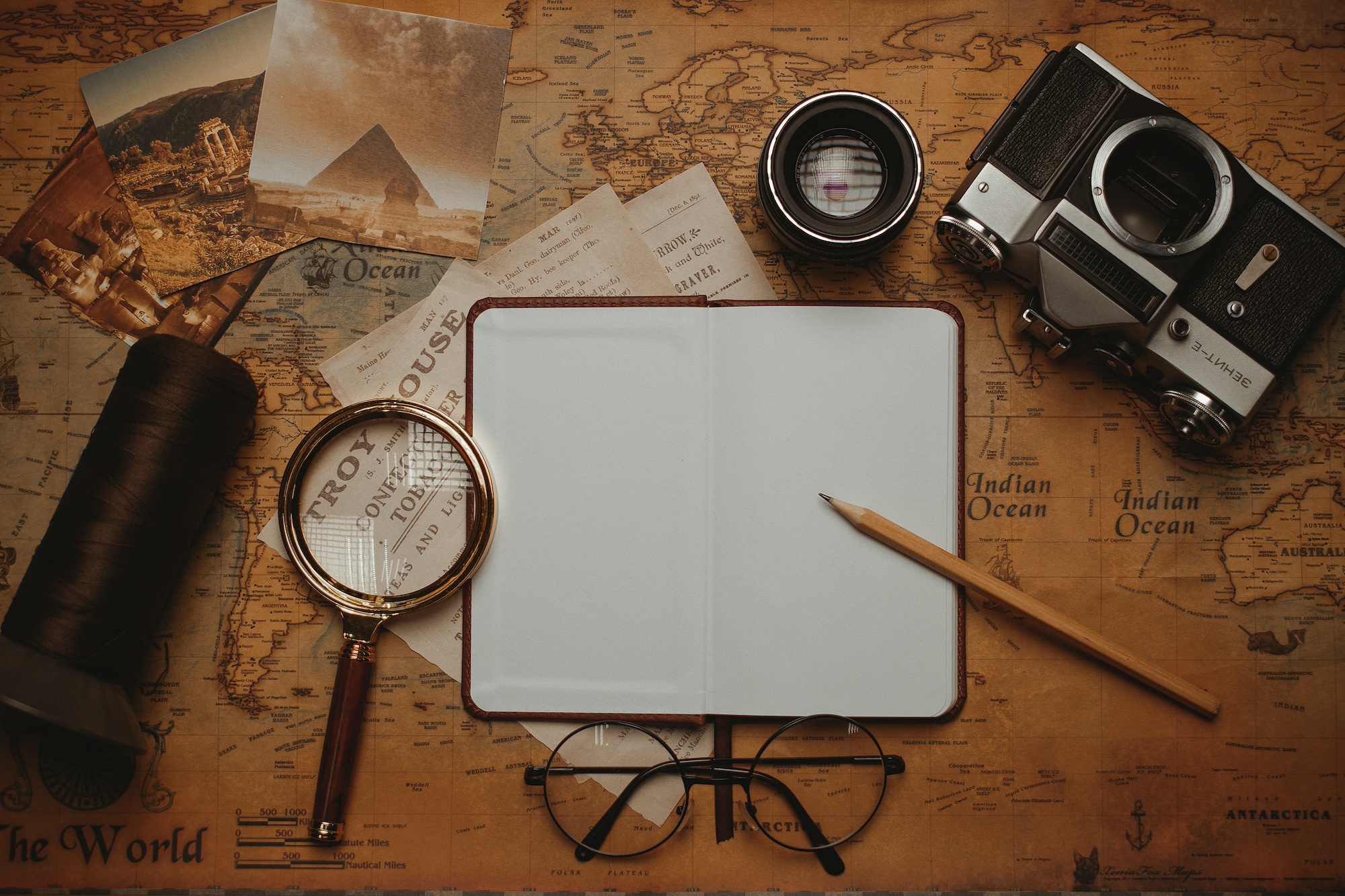 Study materials on a table with a map and magnifying glass signifying search for a tutor